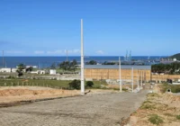 Vista do loteamento com rua pavimentada e mar ao fundo — Loteamento Bella Vista