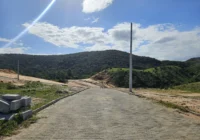 Rua pavimentada do loteamento com vista para montanhas — Loteamento Bella Vista